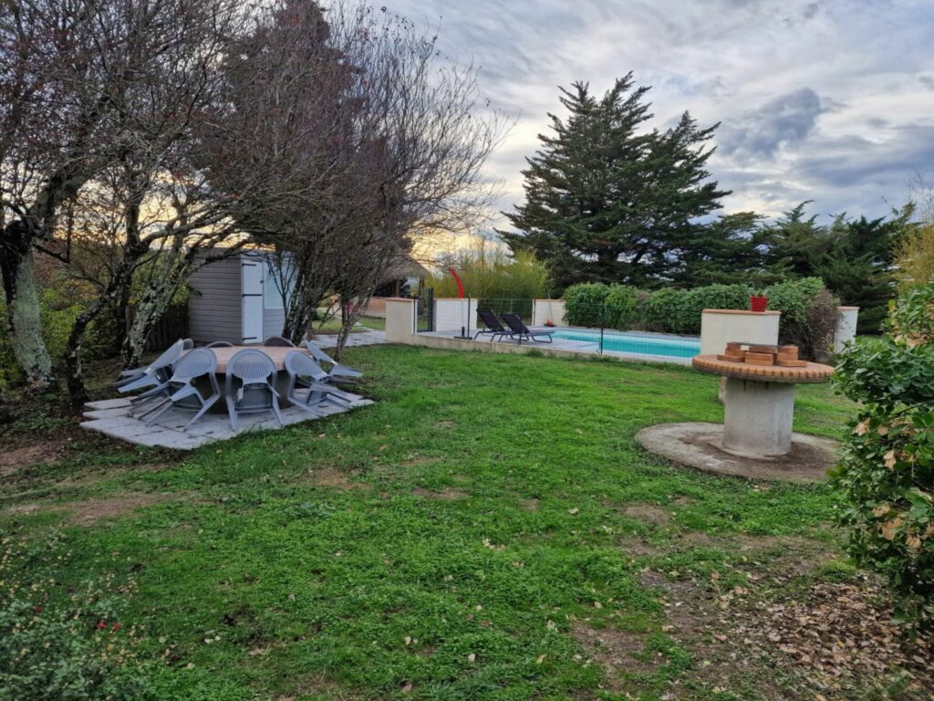 Une grande table ronde extérieure permet de partager les repas dans le jardin, face à la piscine partagée, non loin du barbecue et de la paillotte avec vue sur les Pyrénées.